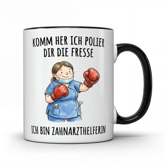 Weiße Tasse mit schwarzem Henkel und schwarzem Rand, bedruckt mit einer Cartoon-Illustration. Eine lächelnde Zahnarzthelferin mit braunen Haaren, Mundschutz und blauer Arbeitskleidung trägt rote Boxhandschuhe. Darüber steht in schwarzer Schrift 'KOMM HER ICH POLIER DIR DIE FRESSE' und darunter 'ICH BIN ZAHNARZTHELFERIN'.